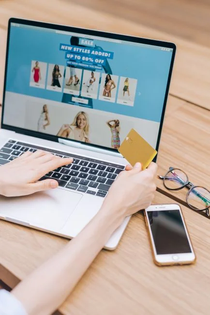 creative Person shopping online using a laptop and credit card, highlighting e-commerce convenience.